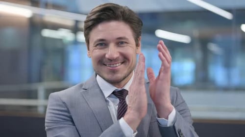 Businessman Smiling and Clapping Hands in the Office