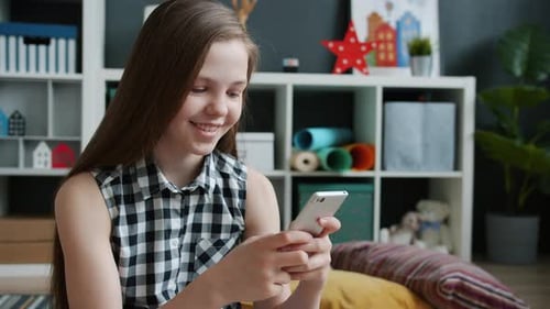 Teen Using Phone Smiling Indoors