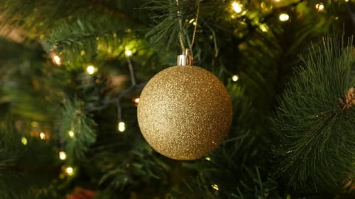 Close-up of sparkling gold bauble hanged on the artificial tree 4K 2160p 30fps UltraHD footage - G