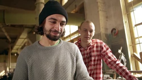 Footage of Two Worker Males Standing in Joinery Smiling and Discussing Project in Slowmotion