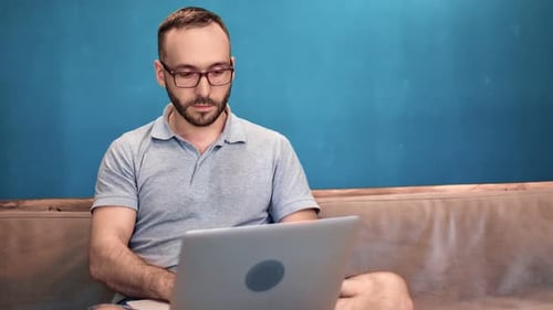 Confident Freelancer Man on Couch Chatting Use Laptop Isolated