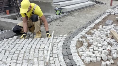 Caucasian Construction Contractor Paving Granite Brick Paths.
