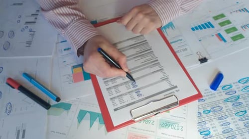 Person Reviewing Financial Data on Desk