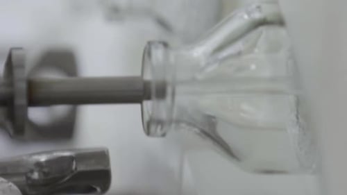 Bouteilles en verre vidéo verticales sur un convoyeur de solutions médicales à la station de remplissage Gros plan sélectif