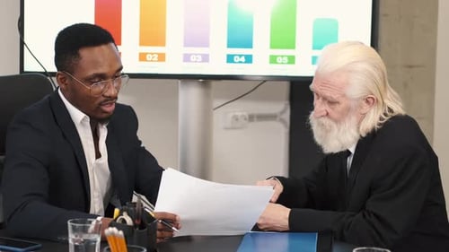 Businessmen Discussing Data in Modern Office Setting