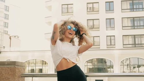 Stylish Woman Dancing Happily in Urban Setting