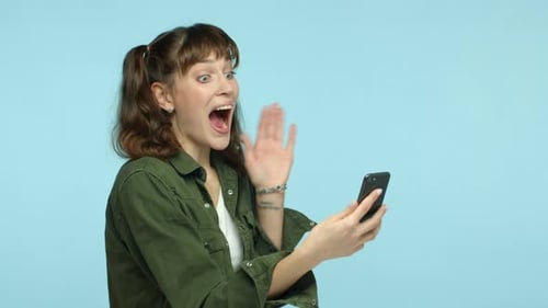 Woman Receives Good News on Smartphone, Reacts Positively