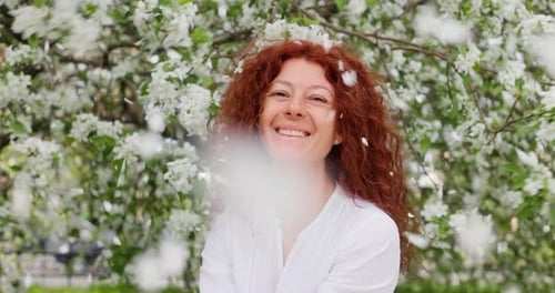 Woman Smiling in Blossoming Apple Orchard
