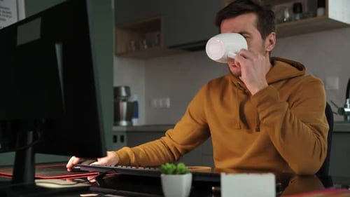 Tired Man Works Late at Workplace Use Computer