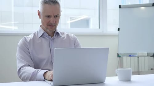 Man Working on Laptop in Bright Office