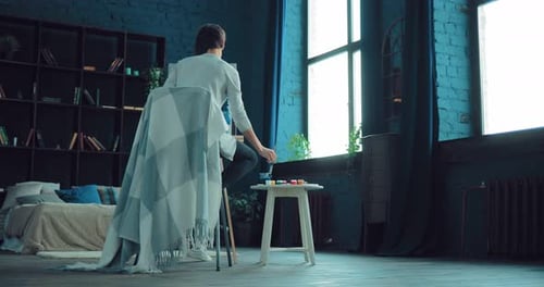 Young Woman Painting in her Home Studio