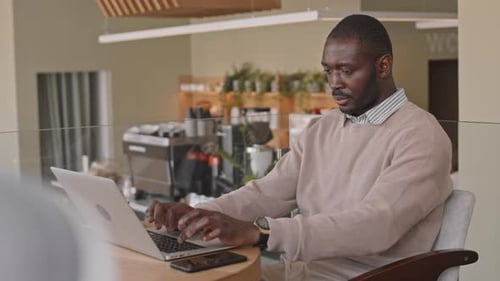 Businessman Working on Laptop in Coffee Shop