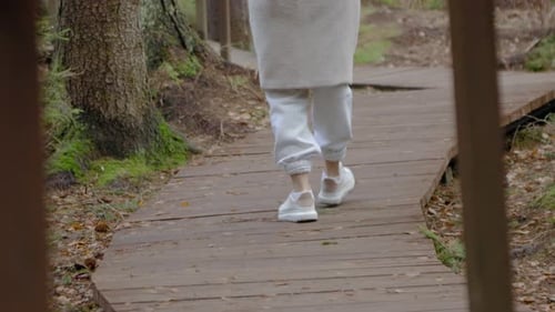 Junge Frau geht den Weg im Wald aus nächster Nähe