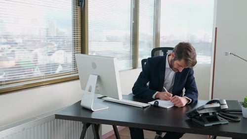 Jeune homme d'affaires travaillant à un ordinateur assis au bureau Workaholic at Work Manager écrit le