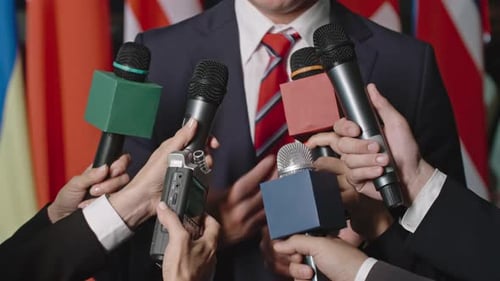Press Conference with Microphones and Flags