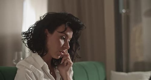 Femme d'affaires parlant sur smartphone à la maison