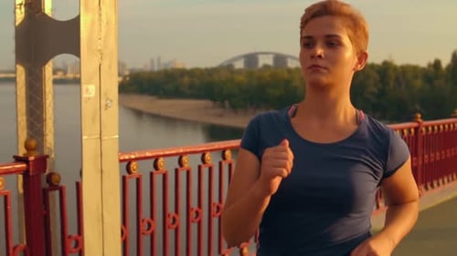 Woman Running on Bridge in Morning Sunlight