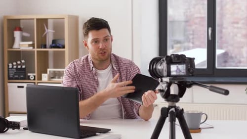 Männlicher Blogger mit Tablet-Pc-Videoblogging zu Hause 11