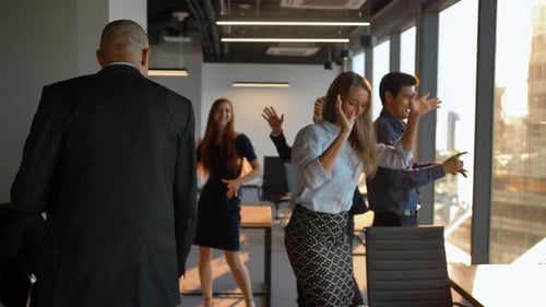 Attractive Confident Businesspeople Dancing Cheerfully in Office in Front of the Camera