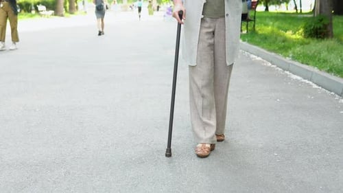 Close Up Senior Woman Legs Walking with Cane in the Park