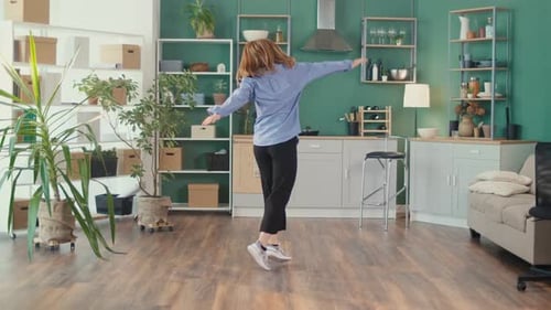 Woman Dancing Freely in Her Modern Apartment