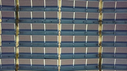 Aerial view of many photo voltaic solar panels mounted of industrial building roof