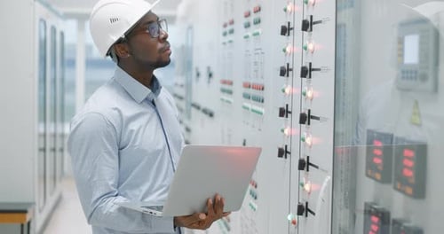 Man Working at Computer in Industrial Facility