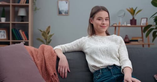 Young Woman Smiling on Sofa at Home