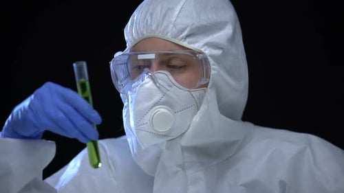Woman in Protective Suit Examining Green Liquid Ionizing Radiation, Illegal Lab
