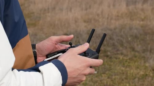 Remote drone in the male hands of a pilot close-up. Flying drone with remote control.