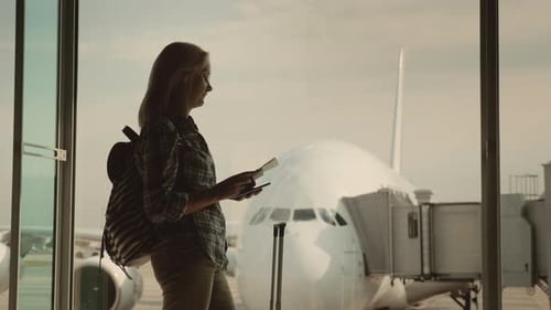 A Young Woman Waiting To Board Her Flight. Holds a Passport and Boarding Pass. Start of the Journey