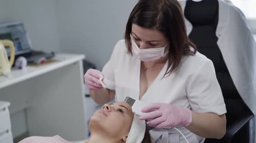 Aesthetician Performing Facial Treatment on Client in Clinic