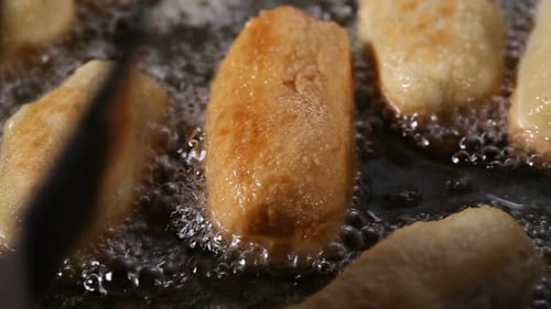 Frying dough balls filled with sausage and cheese in sunflower oil