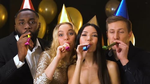 Friends Celebrating with Noisemakers at Party