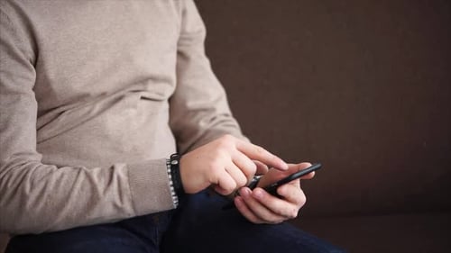 Close Up Shot of a Man's Hands, Who Holds a Smartphone for Checking Social Networks