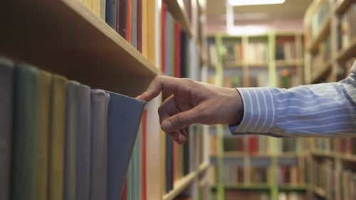 A young man in a bookstore chooses a book to study.