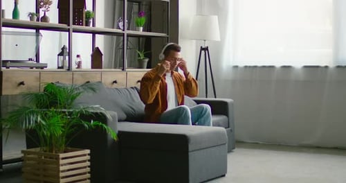 Young Man Listening to Music and Dancing at Home