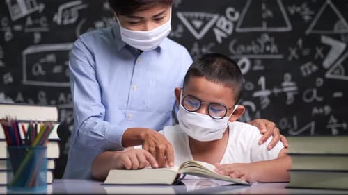 Child Reading with Tutor in Classroom