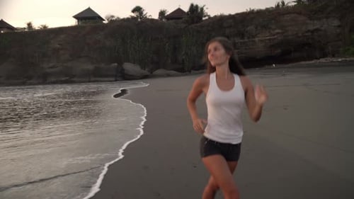 Cheerful Woman Jogging along Ocean Coastline