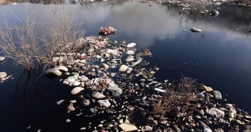 Landfill Polluting Dark Water with Burning Garbage
