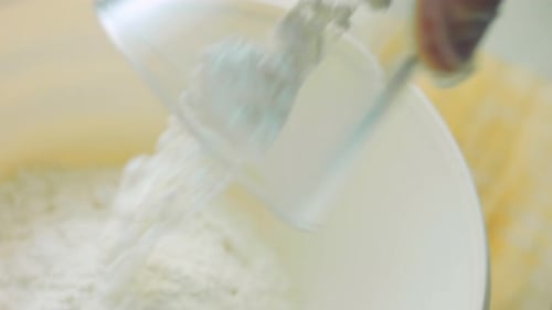 Flour Being Poured Into White Bowl
