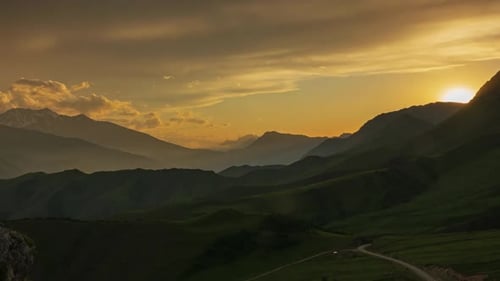 Mountain Landscape at Sunset with Rolling Green Hills