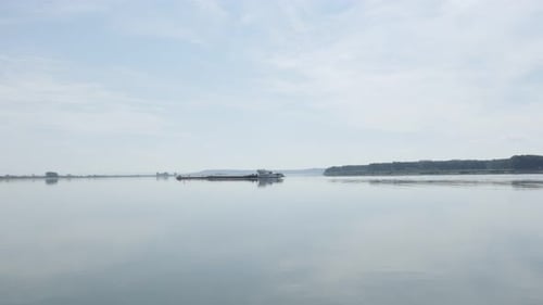 River Danube as border between Serbia and Romania with cargo ship progessing slowly on 4K 2160p 30