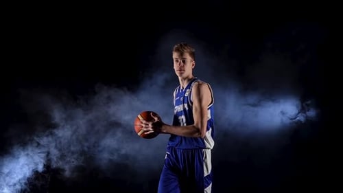 Ein junger Basketballspieler übt einen Aufschlag mit dem Ball
