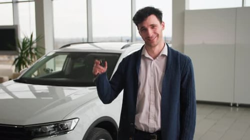 Happy Man Holding Keys Next to New Car