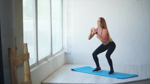 Pretty and Athletic Woman Does Deep Squats To Strengthen the Buttocks in the Gym
