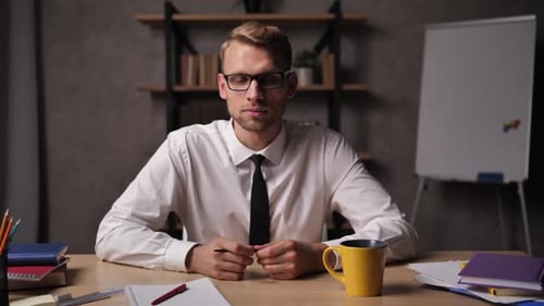 Young Adult Explains Concepts at Desk in Office