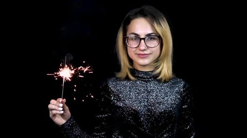 Woman Holds Sparkler in Dark Studio Setting