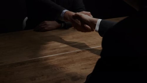 Business Deal Handshake Across Table