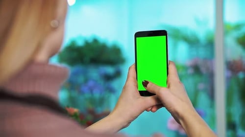 A Woman Florist Takes Pictures of Flowers on Her Smartphone in Her Shop